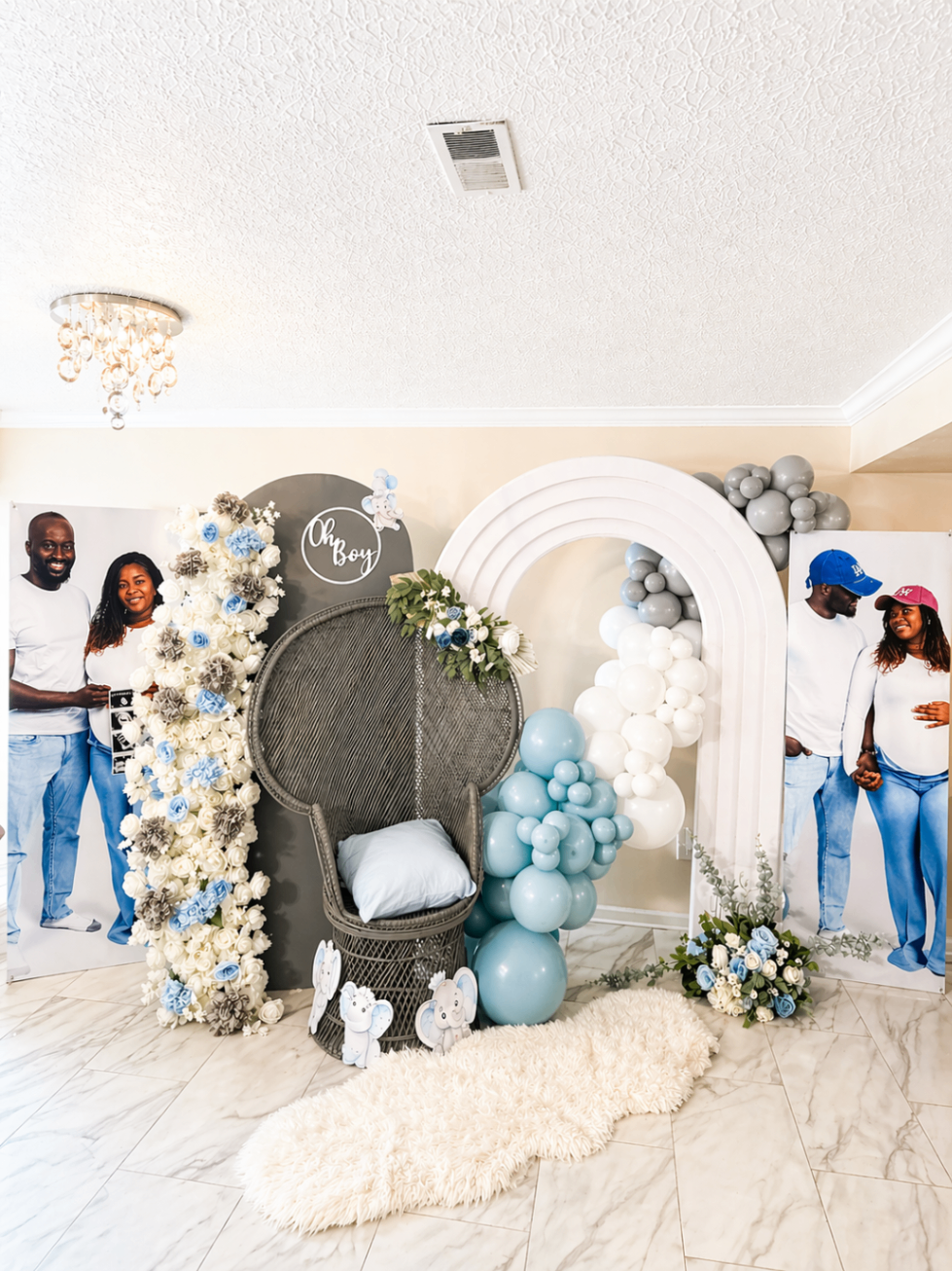 Oh Boy baby reveal installation with family portraits, layered rainbow arch, and balloon styling.