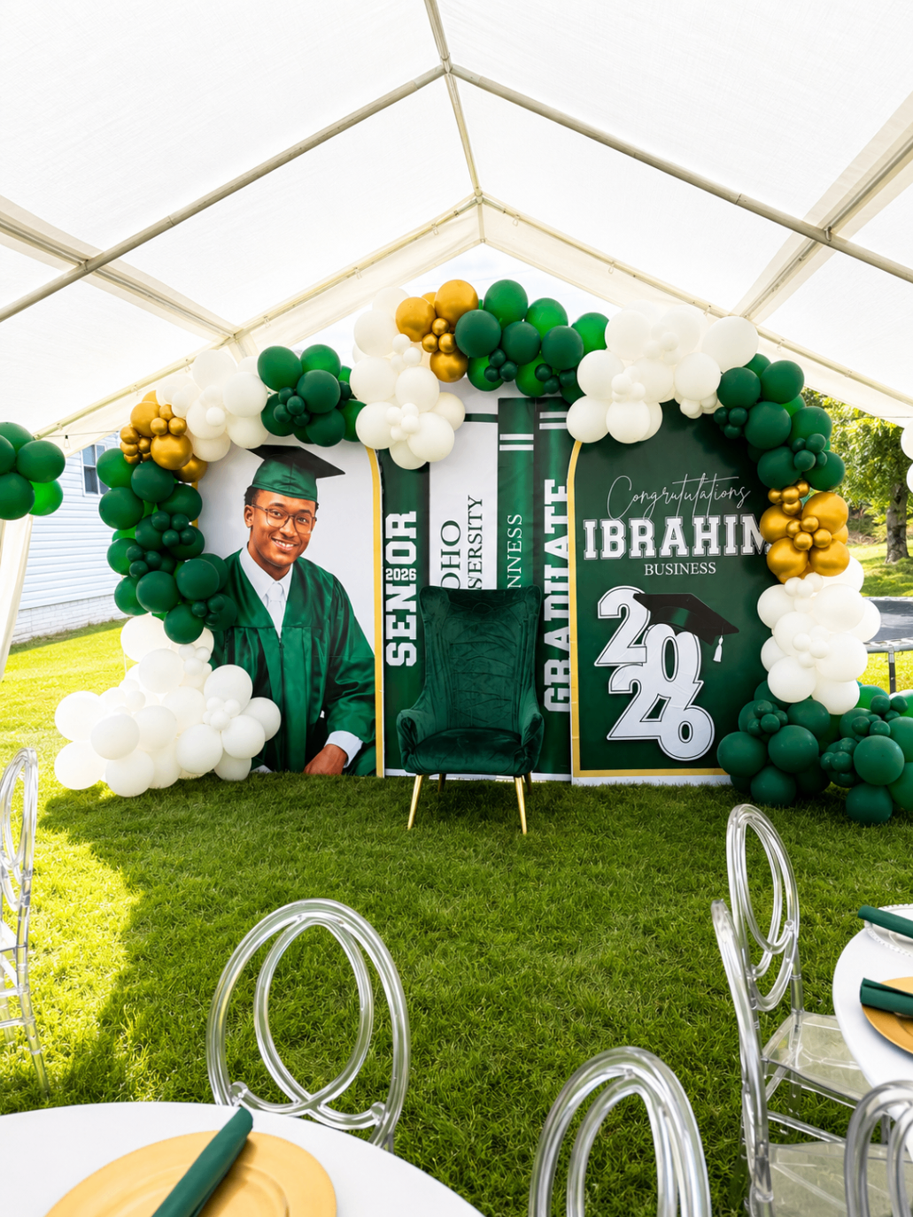 Green graduation installation with balloon arch and custom graduate panels.