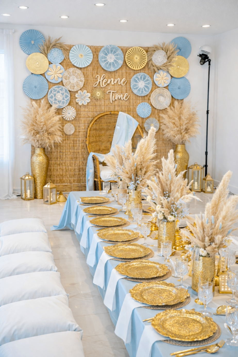 Light blue and gold Henne Time tablescape with pampas styling and woven backdrop.