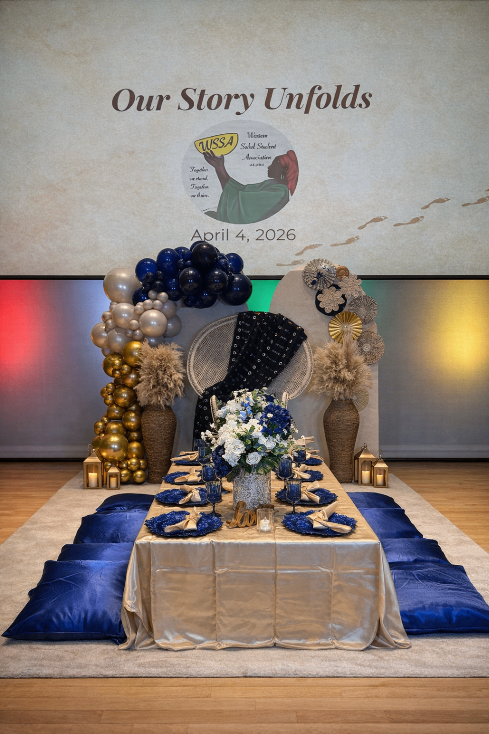 Elegant storytelling tablescape with blue velvet floor seating, warm lanterns, and floral centerpiece.