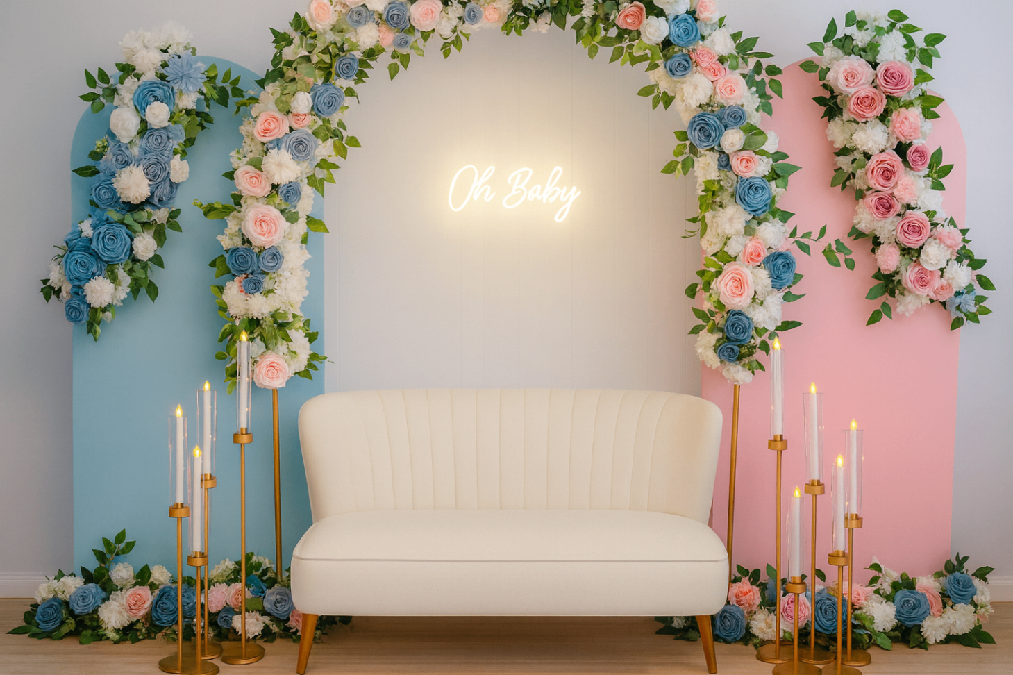 Pastel baby shower installation with floral arch, neon sign, candles, and ivory sofa.